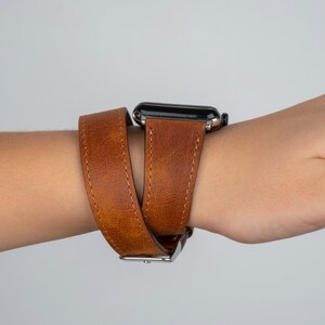 K&ouml;nnte beinhalten: Ein braunes Lederarmband mit doppeltem Wickeldesign. Das Armband ist aus echtem Leder und hat eine silberne Schlie&szlig;e.