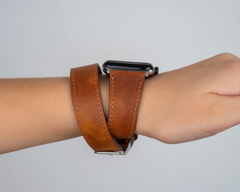 K&ouml;nnte beinhalten: Ein braunes Lederarmband mit doppeltem Wickeldesign. Das Armband ist aus echtem Leder und hat eine silberne Schlie&szlig;e.
