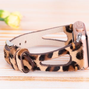 May include: A brown and black leopard print leather watch band with a rose gold Apple Watch.