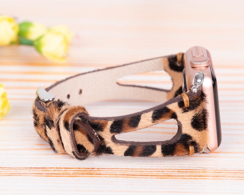 May include: A brown and black leopard print leather watch band with a rose gold Apple Watch.