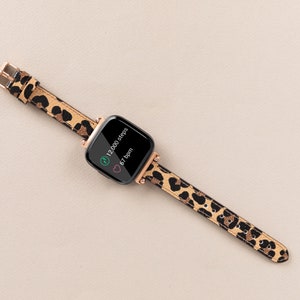 Puede incluir: Un rastreador de fitness negro con una banda de estampado de leopardo. La pantalla muestra "12.000 pasos" y "67 ppm".