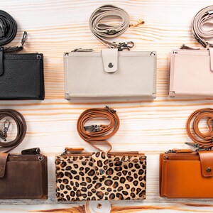 Pu&ograve; includere: Sei portafogli rettangolari con tracolle staccabili disposti su due file. I portafogli sono disponibili in nero, grigio chiaro, rosa pallido, marrone scuro, stampa leopardata e marrone chiaro, con chiusura a bottone automatico e finitura.