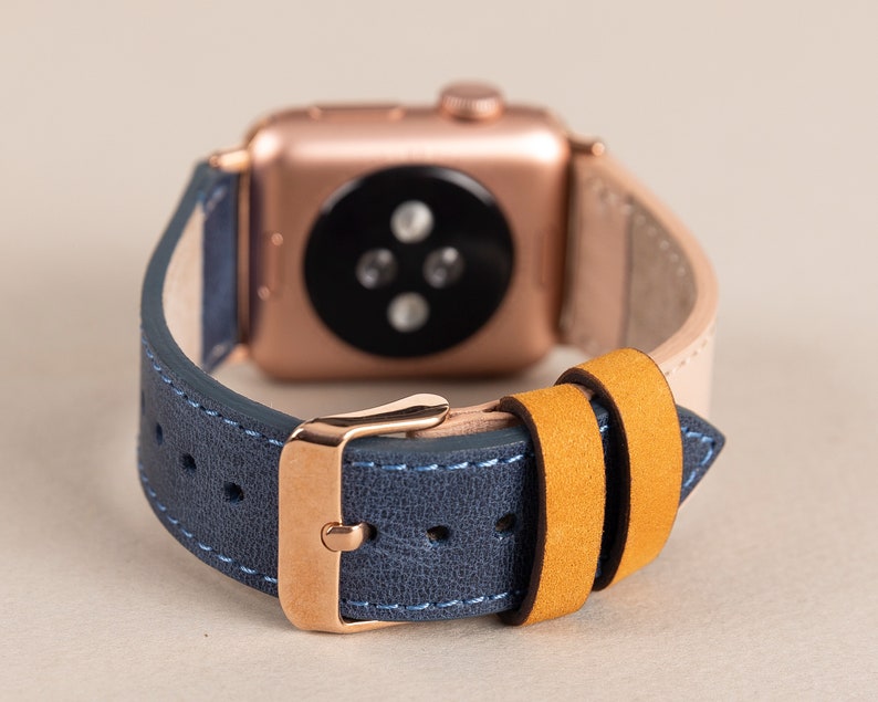 May include: A rose gold Apple Watch band with a blue leather strap and a yellow leather strap. The band is designed to fit a 40mm or 44mm Apple Watch.