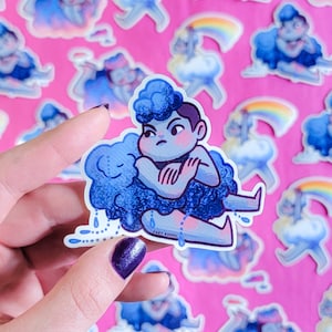 May include: A blue and white sticker featuring a cartoon character with blue hair and a blue cloud. The character is holding a smaller blue cloud and has a sad expression. The sticker has the text "Kary Keppel" at the bottom.