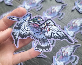 May include: A sticker featuring a stylized pigeon with a sword through its wings and a golden needle. The bird is primarily blue, purple, and gray, with a purple border. The artist's signature, "Kary Keppol," is visible.