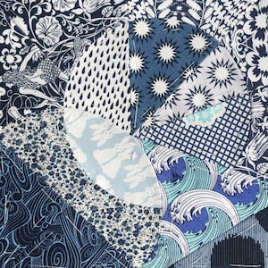 May include: A close-up of a blue and white patchwork quilt with various patterns, including waves, stars, and floral designs.
