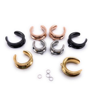May include: A set of eight ear gauges in various colors, including black, silver, gold, and rose gold. The gauges are made of stainless steel and have a smooth, polished finish. The set also includes three small jump rings.