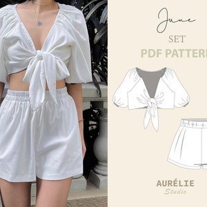 Könnte beinhalten: Ein zweiteiliges Set in Weiß, bestehend aus einem Crop-Top zum Binden mit Puffärmeln und Shorts mit hoher Taille. Das Bild zeigt auch eine Strichzeichnung des Outfits und den Text "June SET PDF PATTERN" und "AURÉLIE Studio".