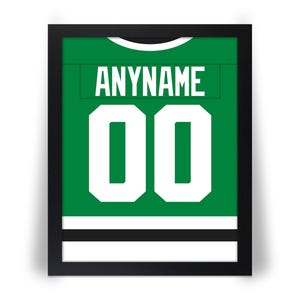 May include: Framed green and white hockey jersey with the name "ANYNAME" and the number "00" in white. The jersey is displayed in a black frame, suitable for wall decor.