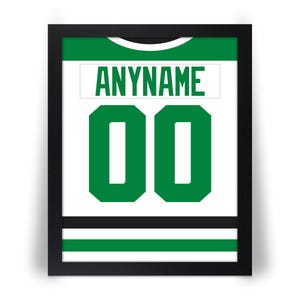 May include: Framed print of a hockey jersey with the text "ANYNAME" above the number "00". The jersey design is white with green accents and a green number. The frame is black.