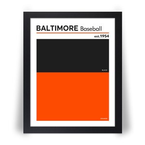 May include: Framed art print featuring a minimalist design with the words "BALTIMORE Baseball" and "est.1954". The artwork is divided into black and orange sections, with the words "BLACK" and "ORANGE" at the bottom. The print is in a black frame.