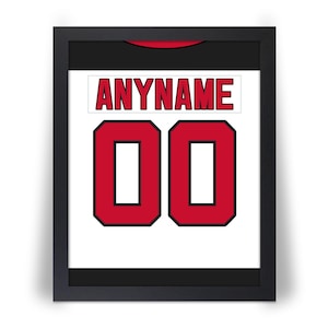 May include: Framed jersey art featuring a white background with the name "ANYNAME" in red letters above the number "00" in a bold red font. The jersey art is framed in a black frame.