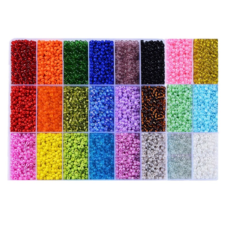 May include: A clear plastic storage box filled with 24 compartments, each containing a different color of seed beads. The beads are small and round, and they are arranged in rows.