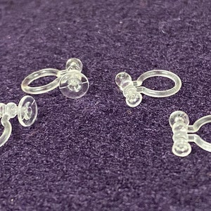 May include: Four clear plastic curtain clips with a ring and a suction cup on each clip.