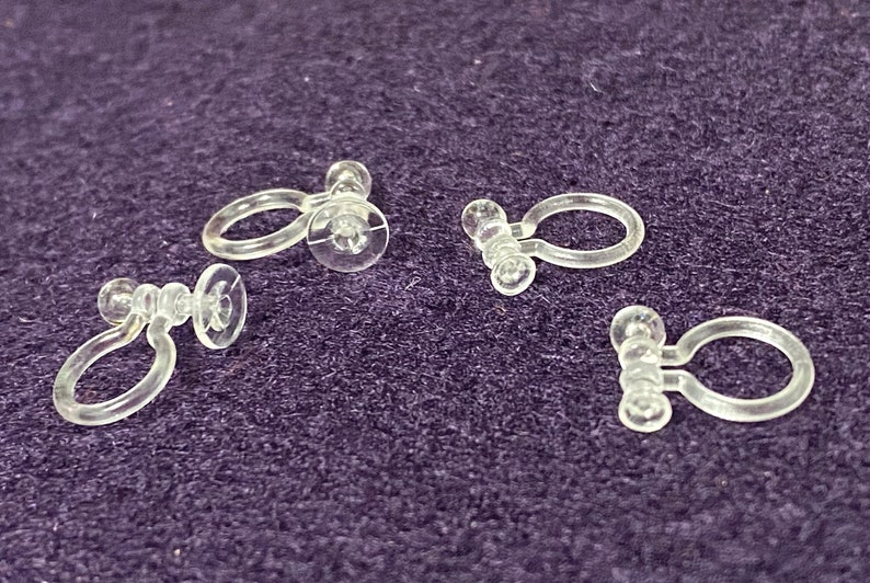 May include: Four clear plastic curtain clips with a ring and a suction cup on each clip.