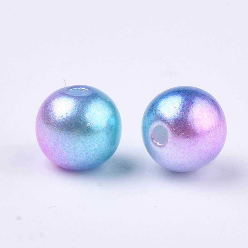 May include: Two iridescent blue and purple round beads with a hole in the center.