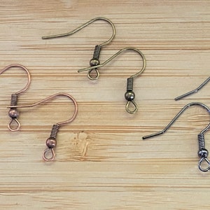 May include: Three pairs of earring hooks, one pair is copper, one pair is silver, and one pair is bronze.