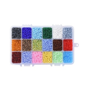 May include: A clear plastic storage box with 16 compartments filled with colourful seed beads. The beads are arranged in rows and columns, with each compartment containing a different colour.