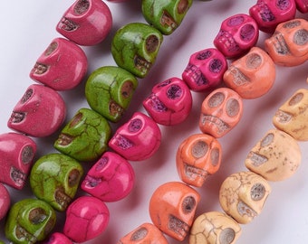 May include: A strand of colorful skull beads made of turquoise. The beads are in shades of green, pink, orange, and cream.