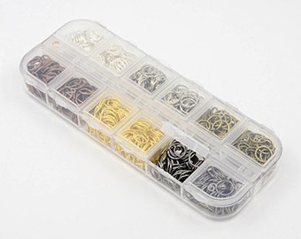 May include: A clear plastic storage box with 10 compartments filled with assorted jump rings. The jump rings are in various sizes and colors, including silver, gold, and bronze.
