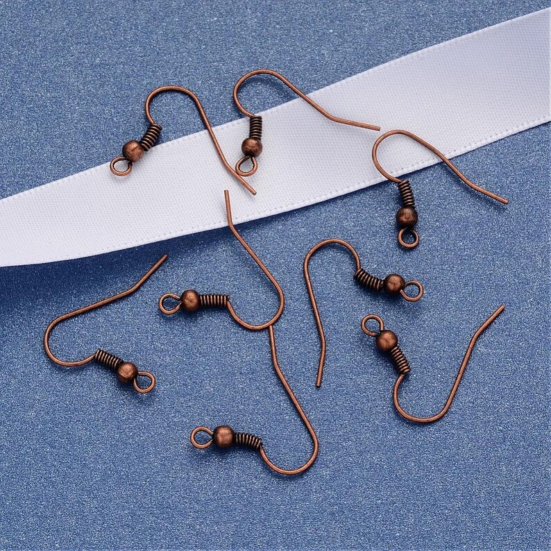 May include: A set of six copper-toned earring hooks. The hooks are made of metal and have a spring-loaded closure. They are perfect for making your own earrings.