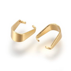 May include: Two gold-toned metal pendant bails, each with a slightly curved shape and a small opening at the top.