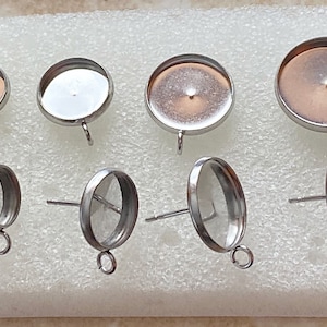 May include: A set of six silver-toned metal earring blanks with round and oval shapes. The blanks have a smooth, shiny finish and are ready to be decorated with your favorite materials.