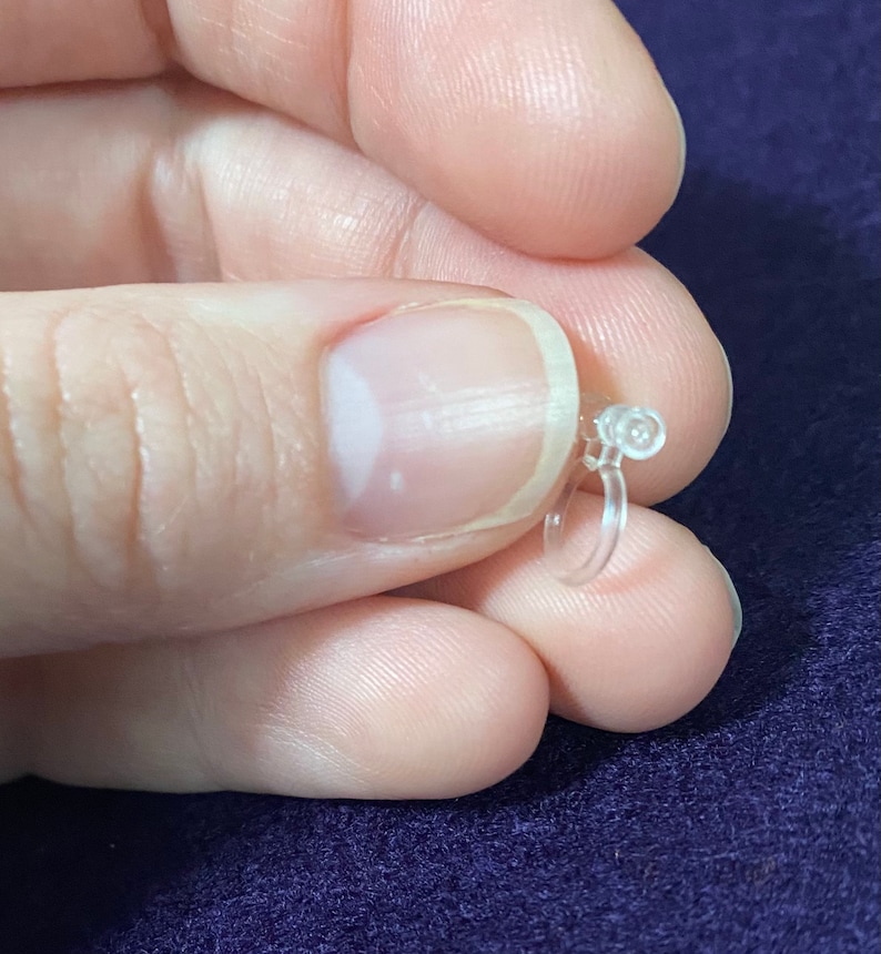 May include: A clear plastic ear cuff with a small, round, clear plastic bead at the top.