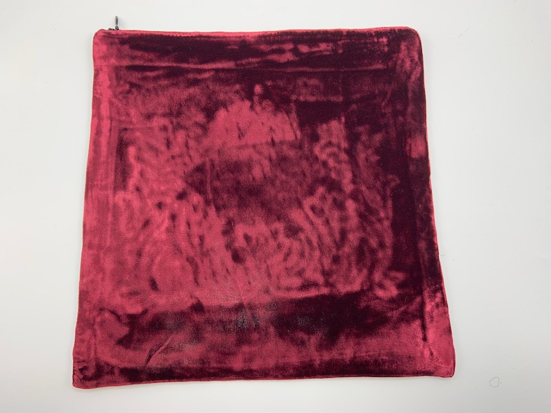 May include: A deep red velvet pillow cover with a zipper closure.
