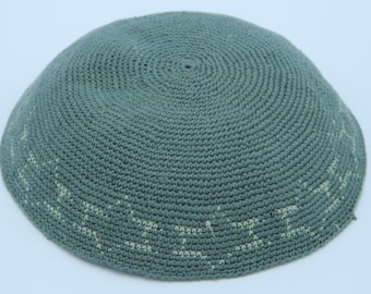 May include: A green crocheted kippah with a white embroidered design.