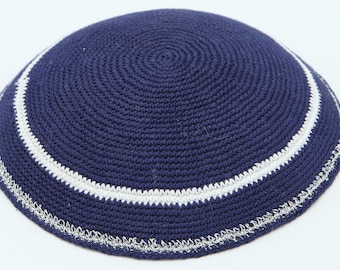 May include: A navy blue knitted kippah with a white trim and a silver edging.