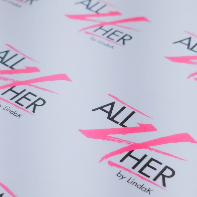 May include: Multiple white sheets of paper with the phrase "ALL HER by Lindak" printed in black and pink. The pink is in a stylized, brushstroke font.