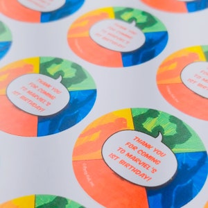 May include: Round stickers with a colorful comic book design. The stickers feature a speech bubble with the text "Thank you for coming to Marvel's 1st Birthday!"