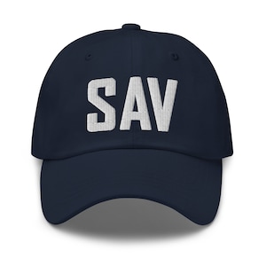 Könnte beinhalten: Eine marineblaue Baseballkappe mit einem weißen, gestickten "SAV" auf der Vorderseite.