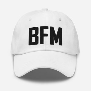 Op de afbeelding: Witte baseballpet met zwarte geborduurde tekst "BFM".