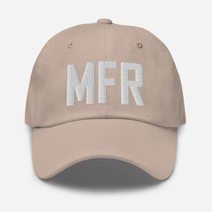 Puede incluir: Una gorra de béisbol de color beige con texto bordado en blanco que dice "MFR".