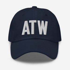 Może przedstawiać: Czapka bejsbolowa w kolorze granatowym z białym haftem z napisem "ATW".
