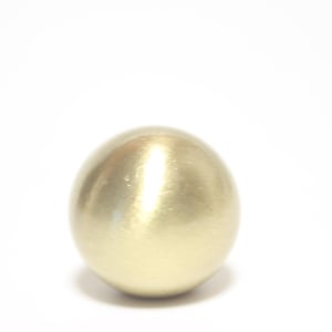 May include: A spherical object with a gold metallic finish. The ball has a smooth surface that reflects light, creating highlights. The object is set against a plain white background.