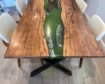 May include: A wooden dining table with a green and white epoxy river running down the center. The table has a black metal base and is surrounded by white chairs.