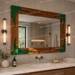 May include: A rectangular wall mirror featuring a natural wood frame with inlaid green resin accents. The mirror has a reflective glass surface and is mounted above a bathroom sink with a faucet, flanked by two vertical wall-mounted light fixtures.
