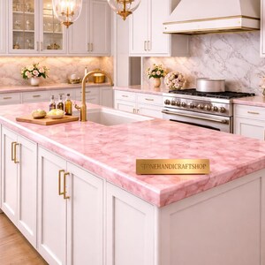 May include: A luxurious kitchen with white cabinetry, gold hardware, and a pink marble countertop. Two gold pendant lights hang above the island. The kitchen features a sink, stove, and a marble backsplash. The countertop has the text "STONEHANDICRAFTSHOP".