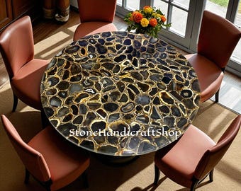 May include: A round dining table with a black and gold agate stone top. The table is surrounded by six brown leather chairs. The text "StoneHandicraftShop" is visible on the table. The table is a unique piece of furniture.