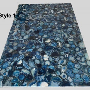 May include: Blue agate countertop with a variety of blue and gray agate slices. The agate slices are arranged in a random pattern and are polished to a high shine.