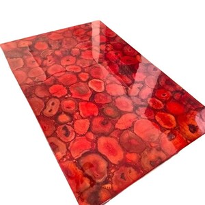 May include: Red agate table top with a glossy finish. The surface is covered in a pattern of red and orange agate slices.