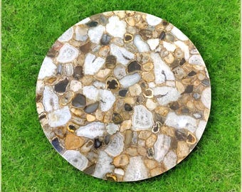 May include: Round agate table top with a variety of brown, white, and gray agate slices. The agate slices are set in a clear epoxy resin.
