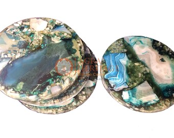 May include: Set of four round coasters with a unique, natural stone design. The coasters feature a mix of blue, green, and white hues, with a glossy finish. The coasters are made of stone and are ideal for protecting surfaces.