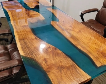 Puede incluir: Una mesa de madera grande con un río de epoxi azul turquesa que atraviesa el centro. La mesa tiene un acabado de alto brillo y está hecha de madera natural.