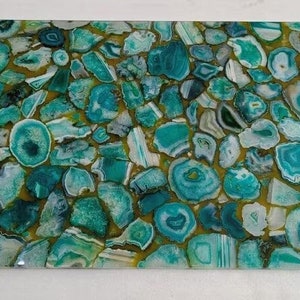 May include: A green and gold agate countertop with a mosaic pattern. The countertop is made of many small pieces of agate, each with a unique pattern and color.