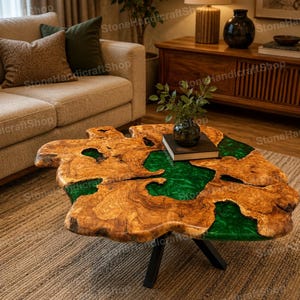 Könnte beinhalten: Ein Couchtisch mit einer naturbelassenen Holzplatte mit unregelmäßiger Maserung und einer Einlage aus durchscheinendem smaragdgrünem Harz, die die Hohlräume ausfüllt, getragen von drei schwarzen Metallbeinen in einer Dreibeinkonstruktion.