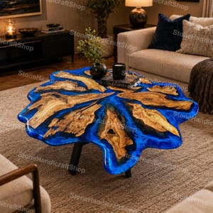 May include: A distinctive coffee table with a live edge design. The table showcases a vivid blue epoxy resin river flowing between natural wood sections. It has black metal legs and is a striking centerpiece for a living room.